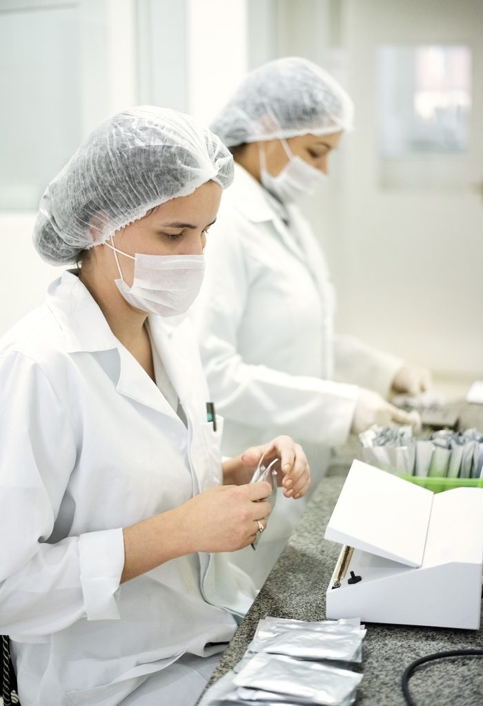 Technicians in a sterile cleanroom performing precision assembly